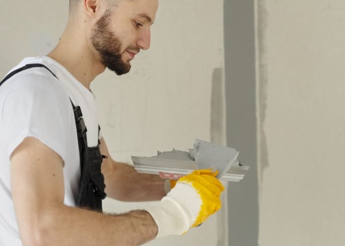 medium-shot-worker-using-plastering-trowel-min